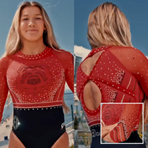 The image showcases a red and black long-sleeved gymnastics leotard, displayed in front and back views. The red mesh sleeves and upper bodice feature an elaborate pattern of small silver rhinestones. A horizontal rhinestone band divides the red top from the solid black bottom. The back has a unique open design with crisscrossing straps. Logos in silver rhinestones, "SEC" on the front hip and "Dawgs" on the back.