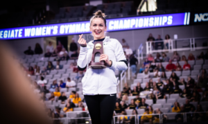 Norah Flatley makes a "money" gesture while accepting an NCAA trophy.