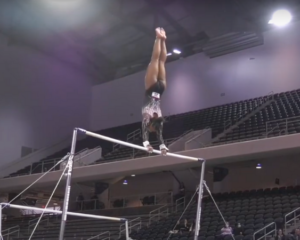 Selena Harris performs a handstand on uneven bars