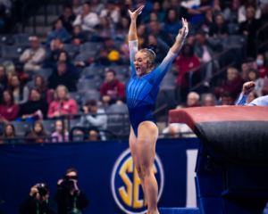 Savannah Schoenherr salutes to the judge with a smile on her face after finishing her vault