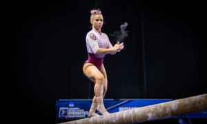 Ragan Smith claps during her beam choreography, creating a chalk cloud