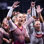 Oklahoma gymnasts celebrating after a hit routine from their teammate