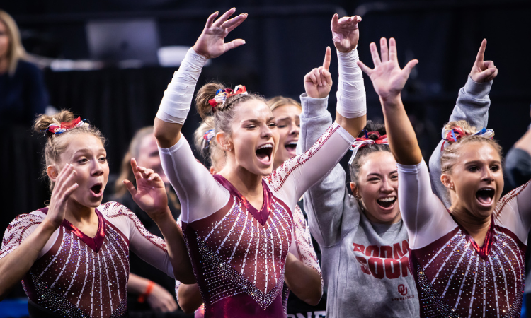 Oklahoma gymnasts celebrating after a hit routine from their teammate