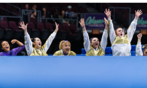 Washington gymnasts celebrate a teammate performing on floor