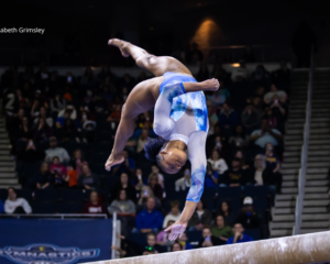 Trinity Thomas performs a one-handed back handspring on balance beam