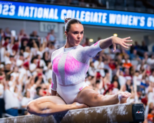 Maile O'Keefe poses on beam and flairs her wrist