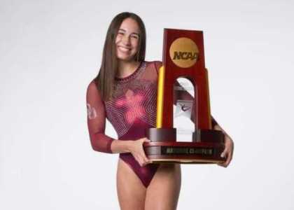 Kamila Pawlak poses holding an NCAA trophy