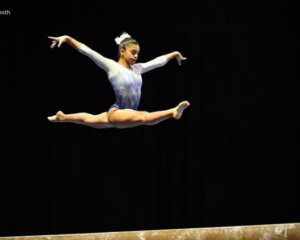 Tiana Sumanasekera performs a split jump on beam