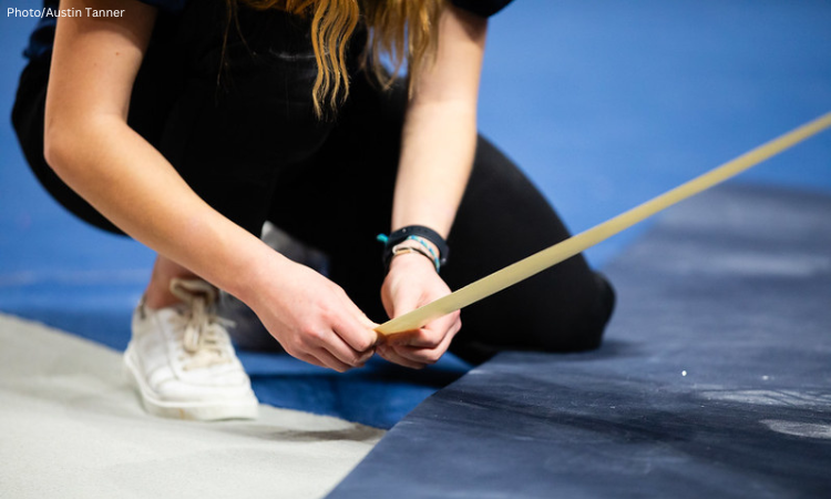 A manager lays tape on the floor exercise