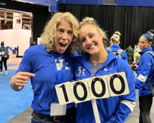 Jenny Hansen Hecht and Raena Worley stand with the perfect 10 sign