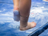 A gymnast rubs her foot before floor.
