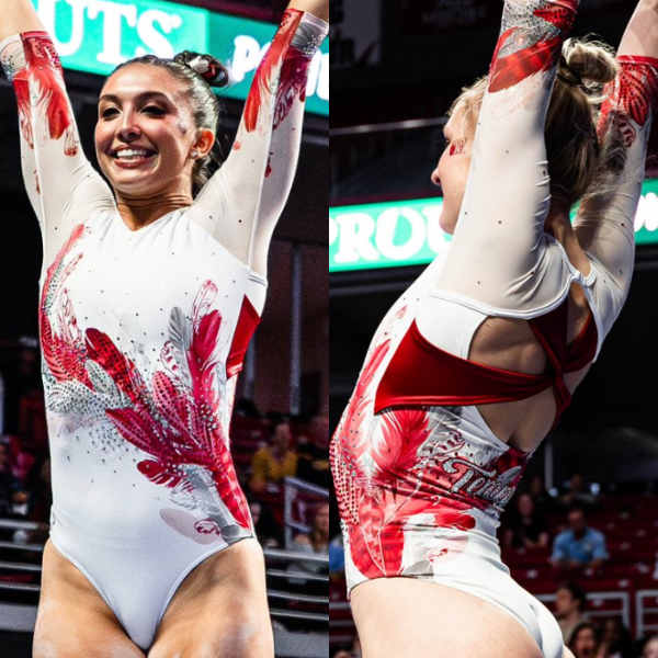 A split image showing the front and back of a white leotard with red and silver accents. The front features a stylized feather design in red and silver, with the pattern radiating outwards. The back of the leotard has a large red cutout and the same feather/floral design wrapping around the side. The leotard also features the feather design on the sleeves.