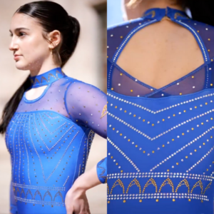 A gymnast is seen wearing a royal blue leotard with a high-neck design and sheer mesh sleeves. The bodice features gold and silver rhinestone detailing arranged in an elegant chevron and arch pattern. The back of the leotard has a keyhole cutout with a high neckline closure, continuing the sophisticated rhinestone embellishments.