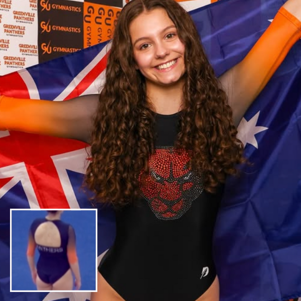 A gymnast wearing a black leotard with black to orange ombre sleeves. On the chest is a large rhinestone panther head. In the bottom left corner is an image of the back, which has a large semi-circle-shaped hole with the word "Panthers" underneath in silver rhinestones.