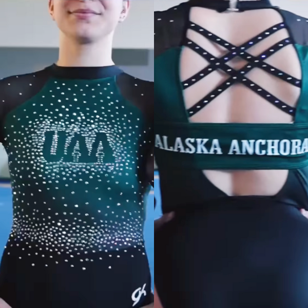 A gymnast wearing a dark green and black University of Alaska Anchorage (UAA) leotard. The front is decorated with small white rhinestones creating a gradient from the logo down. The back has black criss-cross straps with white rhinestones and the words "Alaska Anchorage" across the back.