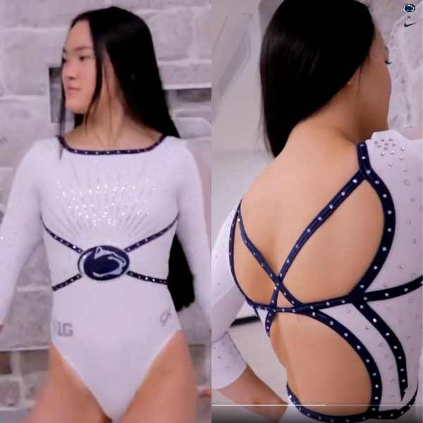 A white gymnastics leotard with long sleeves and navy blue detailing. The front has a sleek, starburst rhinestone pattern extending from the Penn State logo at the waist. The back features an intricate open-back design with navy blue crisscross straps adorned with rhinestones.
