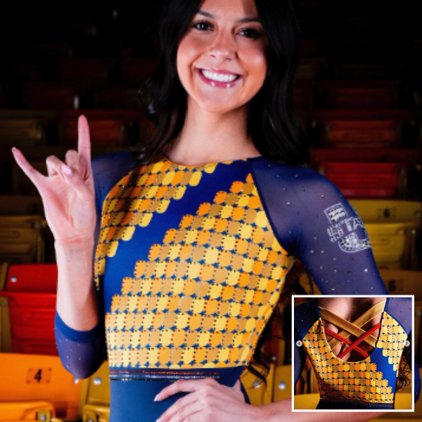 A gymnast in a long-sleeved navy blue and golden-yellow leotard. The front is adorned with a golden geometric pattern that fades into the navy sleeves. The back has a criss-cross strap design, visible in the inset. The combination of intricate patterns and subtle rhinestones enhances the bold color scheme.