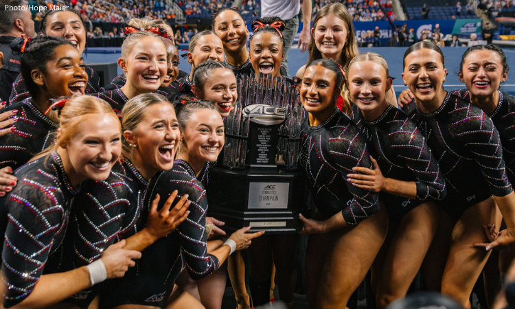 N.C. State gymnasts hold the ACC championship trophy