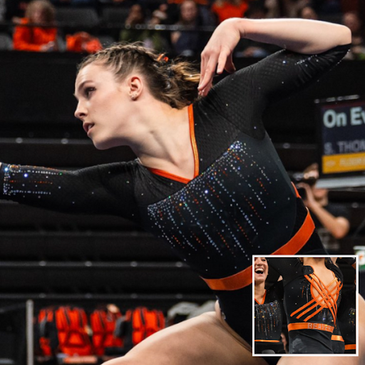 Oregon State in a black leotard with orange embellishments, orange sparkles and a strappy open back