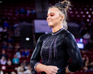 Jaly Jones stands with one arm across her stomach in a black leotard.