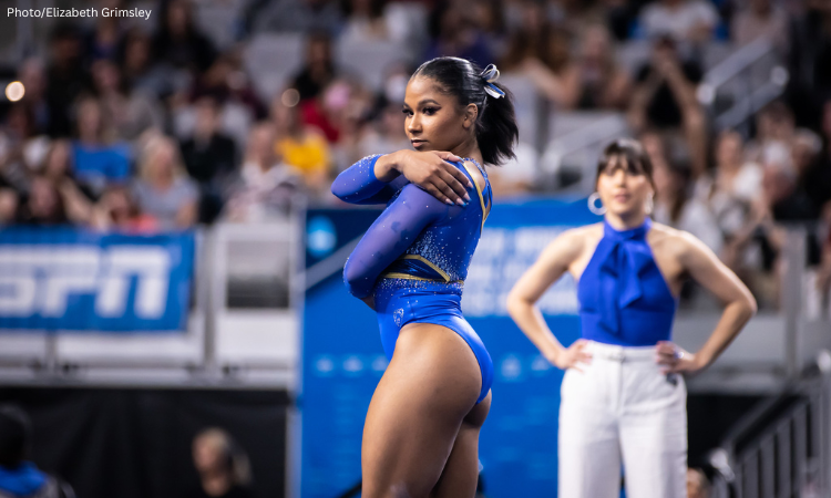 Jordan Chiles holds her arms around herself as she dances on floor.
