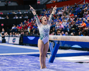 Giana Kalefe saluting and celebrating after her beam routine