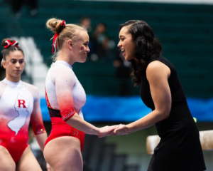 Anastasia Candia supports an athlete before her beam routine.