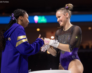 Washington's Mary McDonough fist bumps a teammate with her hands still in grips.