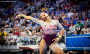 Elle Mueller poses with one hand on her hip and the other outstretched on floor for Oklahoma.