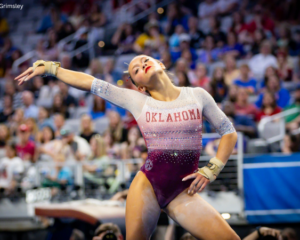 Elle Mueller poses with one hand on her hip and the other outstretched on floor for Oklahoma.