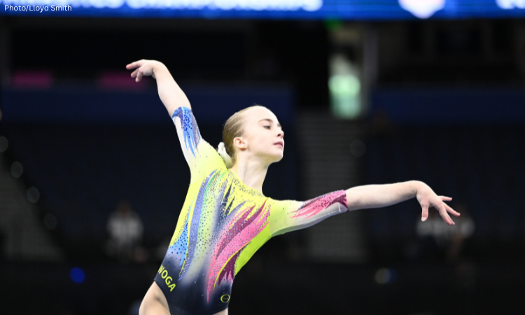 Claire Pease poses on floor with her wrists flexed.