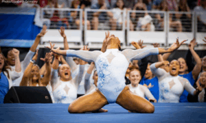 Jordan Chiles of UCLA finishes her floor routine at 2025 national finals while teammates cheer in the background.