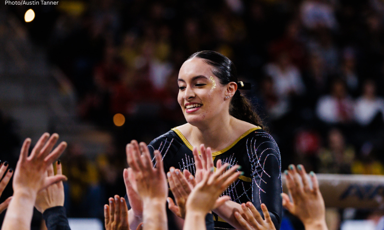 Iowa gymnast Karina Muñoz gives her teammates high fives.