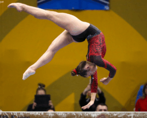 Maryland gymnast Maddie Komoroski does a one arm backhand spring on beam.