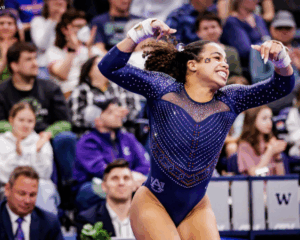 Sophia Bell, Auburn, raises her arms in celebration on floor