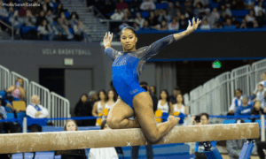 Jordan Chiles, in a blue UCLA leotard poses on the beam.