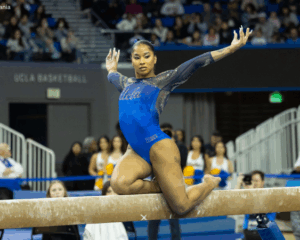 Jordan Chiles, in a blue UCLA leotard poses on the beam.