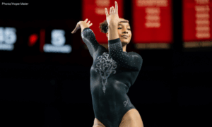 CaMarah Williams dances on floor poses her hands with wrists flexed by her face.