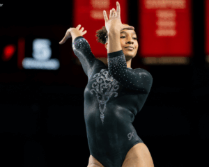 CaMarah Williams dances on floor poses her hands with wrists flexed by her face.