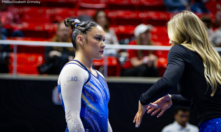 Ciena Alipio of UCLA gets some advice from her coach before her routine.
