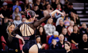 Bailey Bourgeois of Texas Woman's poses during her floor routine with one hand on her hip and the other arm extended to the side.