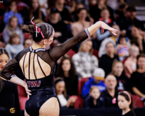 Bailey Bourgeois of Texas Woman's poses during her floor routine with one hand on her hip and the other arm extended to the side.