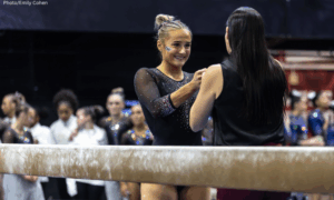 Sophia Isbell from Texas Woman's gets a fist bump from her coach before her beam routine.