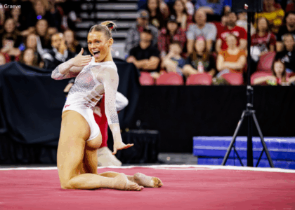 Avery Neff poses on floor with one hand in front of her mouth