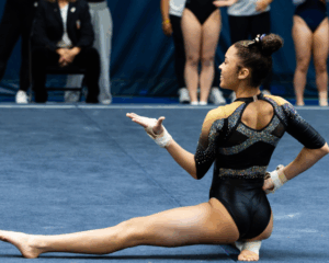 A gymnast holds her final floor routine pose