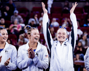Air Force student athletes smile at a women's gymnastics meet against Denver in March 2024