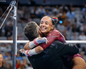 Faith Torrez embraces her coach after her bar routine.
