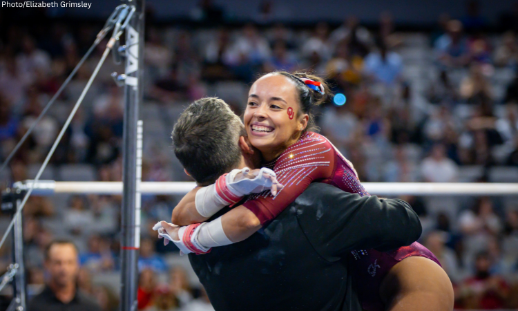 Faith Torrez embraces her coach after her bar routine.