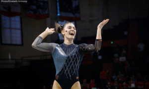 Ellie Weaver of OSU smiles with both hands in the air.