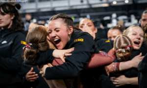 Minnesota gymnasts embrace after qualifying to the national final.